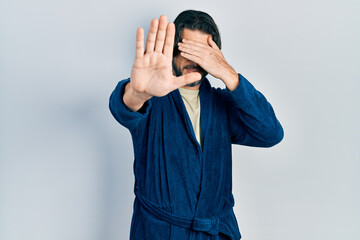 Sticker - Middle age caucasian man wearing bathrobe and glasses covering eyes with hands and doing stop gesture with sad and fear expression. embarrassed and negative concept.