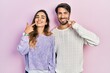 © Krakenimages.com - Young hispanic couple wearing casual clothes smiling cheerful showing and pointing with fingers teeth and mouth. dental health concept.