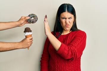 Poster - Beautiful brunette woman saying no to sweets on a healthy diet skeptic and nervous, frowning upset because of problem. negative person.