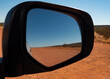 Remote Outback red centre Central Australia track travel in rear view mirror