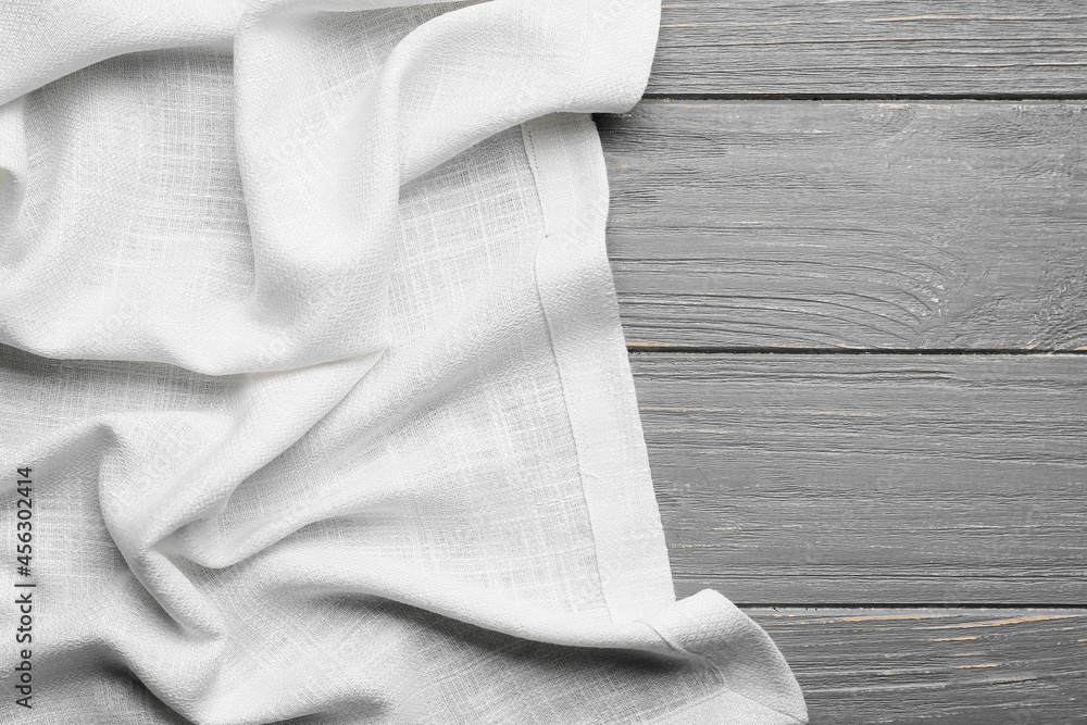 Fabric napkin on grey wooden background, closeup