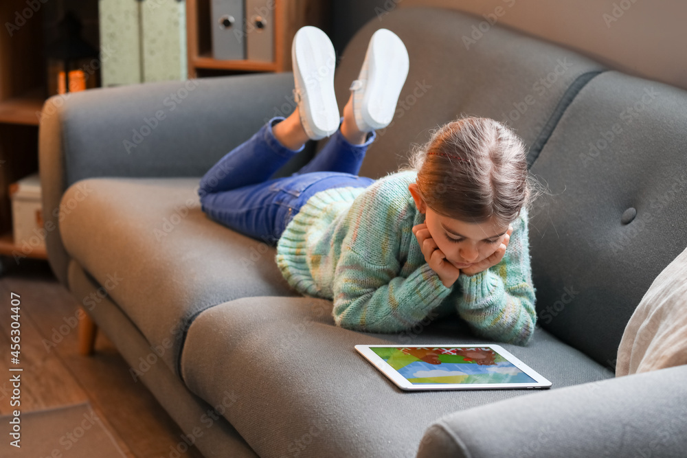 Cute girl watching cartoons at home