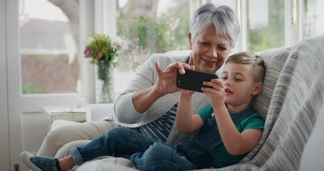 happy little boy using smartphone showing grandmother how to use mobile phone teaching granny modern technology intelligent child helping grandma at home 4k