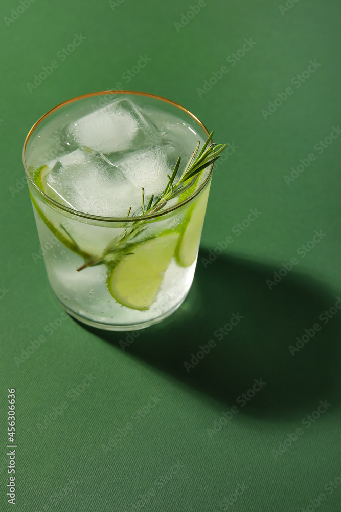 Glass of cold gin and tonic on color background