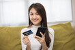 © Chanakon - Shopping online. Young asian teenage girl input the serial number of credit card to smartphone for shopping payment. Buy item online delivery at home. Smiling female feeling happy.