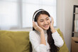 © Chanakon - Relaxing time on sofa. Beautiful young asian woman lay down on sofa and listening to the music with headphone. She has rhythm Lifestyle in living room at house in the morning.