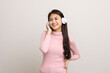 © Chanakon - Cheerful asian female teenager listen to the music with white headphone on isolated. Beautiful young woman in pink shirt hand touch a wireless headphone having fun with the music in  room.