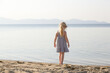 © triocean - Adorable toddler girl in striped dress enjoying a day at the beach. Idyllic summer vacation.