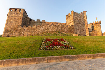 Wall Mural - Ponferrada, Spain. Tau cross made with flowers in front of the Castillo de los Templarios (Castle of the Knights Templar), a medieval fortress