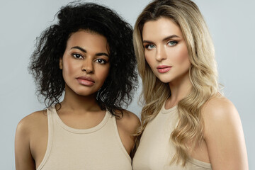 Wall Mural - portrait of caucasian and african american women on gray background.