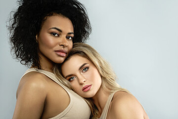 Wall Mural - portrait of caucasian and african american women on gray background.