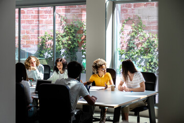 Multiracial group of colleagues chat in office. Copy space.