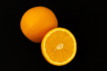 Wall Mural - Closeup shot of a sliced orange isolated on a dark background