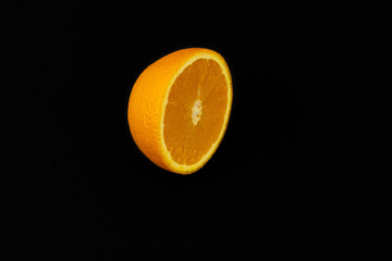 Poster - Closeup shot of a sliced orange isolated on a dark background