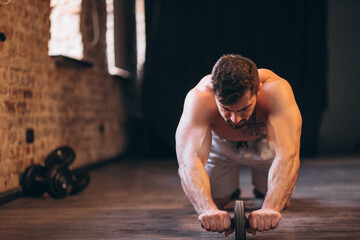 Wall Mural - Fit man at the gym with dumbbells