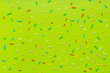 trendy pattern of colorful sprinkles for background of design banner, poster, flyer, card, postcard, cover, brochure over green