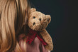 a lonely girl hugs a teddy bear. a lost childhood. an orphan child