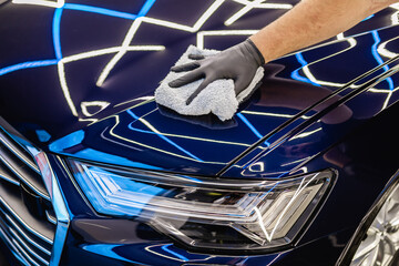 Wall Mural - A man cleaning car, car detailing (or valeting) concept. Selective focus..