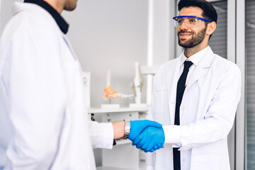 Professional two scientist man research and working doing a chemical experiment while making analyzing and mixing liquid in test tube.Young science man dropping sample chemical on glass at laboratory