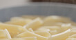 boiled penne pasta in blue bowl closeup