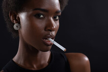 Sexy African American Woman Smoking Cigarette On Black Dark Background.