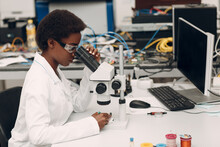 Scientist African American Woman Working In Laboratory With Electronic Tech Instruments And Microscope. Research And Development Of Electronic Devices By Color Black Woman.