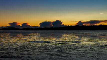 Wall Mural - A golden sunset reflecting over the mudflats of Kirkcudbright Bay in winter