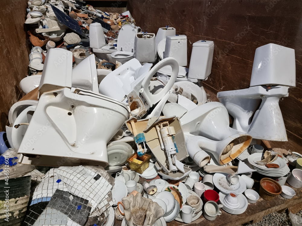 Ceramic trash in a recycling container. Broken toilet seats, kitchen ...