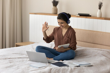 ready for learning. biracial lady in headset remote student sit on bed before pc screen make videoca