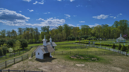 Wall Mural - Aerial view of restored barn and a beautiful landscape field in spring