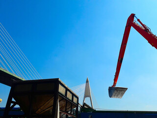 Large Orange scoop Are scooping the white Urea chemical fertilizer From a pontoon boat to unload
