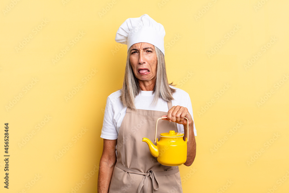 middle age chef woman feeling disgusted and irritated, sticking tongue ...