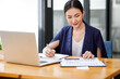 © David - Shot of a asian young business Female working on laptop computer in her workstation.Portrait of Business people employee freelance online marketing e-commerce telemarketing concept.