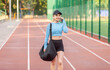 © splitov27 - Young athletic woman with training bag going to workout and talking on the phone at the stadium