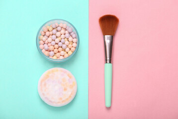 Wall Mural - Powder Balls with makeup brush on pink blue background. Cosmetics. Top view