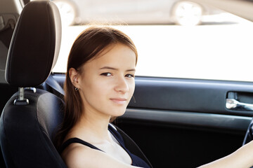 student in car in a driving school at a driving lesson behind the wheel of a car, teenage girl takes a driving exam