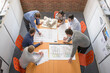 © Image Source Limited - Team of architects discussing plans in meeting room