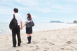 © Image Source Limited - Young couple holding hands on beach, rear view
