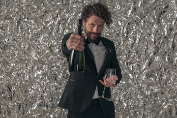 Sticker - bearded young groom holding glasses and showing champagne bottle