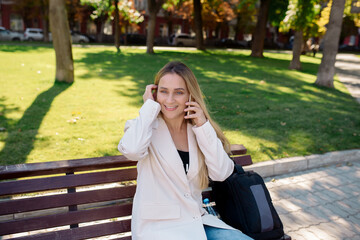 Wall Mural - Young scandinavian blonde woman talking on mobile while sitting on a