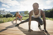 © Cultura Allies - Couple crouching stretching legs