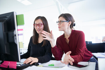 Colleagues working in office, using computer