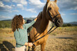 © ADDICTIVE STOCK - Smiling woman caressing horse muzzle in sunshine