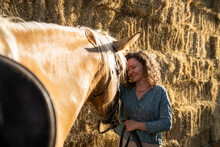 Smiling Woman Caressing Horse Muzzle In Sunshine
