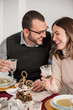 © ADDICTIVE STOCK - Crop happy couple with champagne celebrating Christmas Day at home