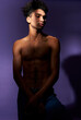 © Kostiantyn - Verticale portrait of young man standing in casual pose in shadow. Muscular transgender male