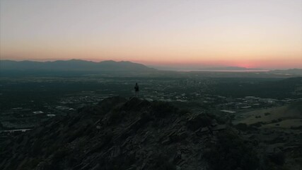 Wall Mural - 4K Epic Aerial shot of woman hiker on top of mountain Salt Lake City Utah sunset turn around