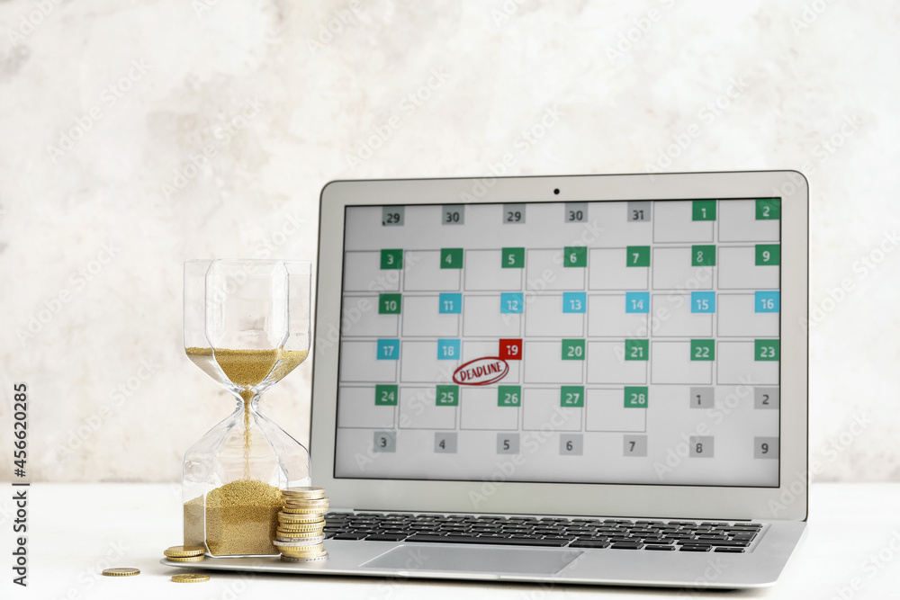 Hourglass, coins and laptop with calendar on light background. Deadline concept