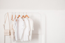 Rack With Stylish Clothes Near Light Wall