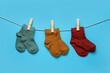 © Pixel-Shot - Different baby socks hanging on rope against color background